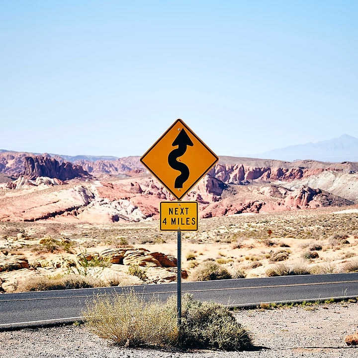 windy road sign in desert